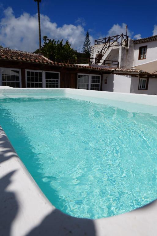 La piscina de La Paredita con la casa y el cielo de Tenerife al fondo